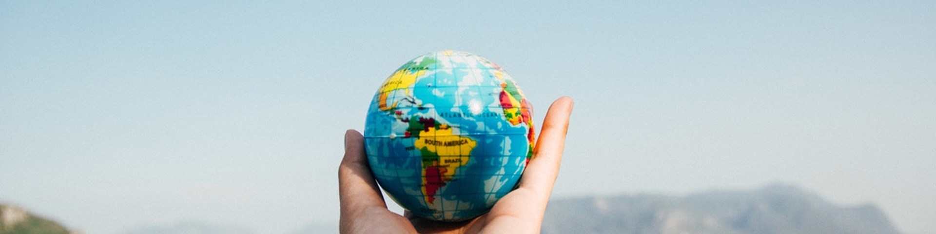 Traveller holding small globe, covered by travel insurance 